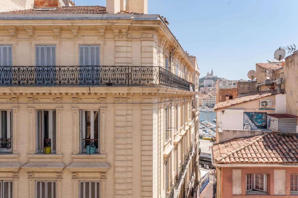 uma vista para um edifício de apartamentos com uma varanda em Residhotel Vieux Port em Marselha