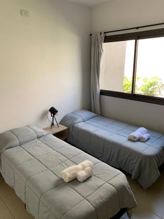 two beds in a room with a window at Moreno Park Complejo Residencial 1 in Ciudad Lujan de Cuyo