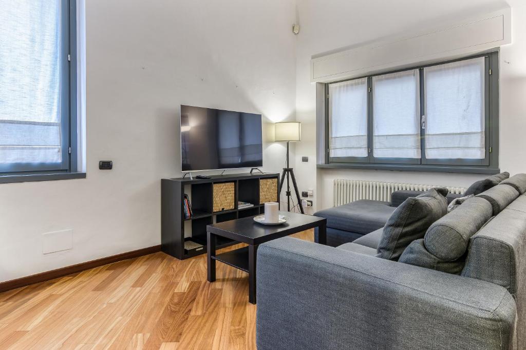 a living room with a couch and a tv at BePlace Apartments in Dateo in Milan
