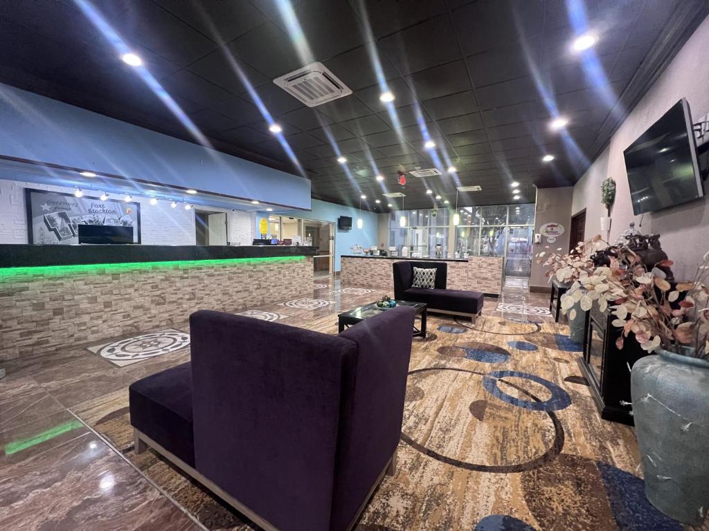 a lobby with chairs and a bar in a building at Super 8 by Wyndham Ft Stockton in Fort Stockton