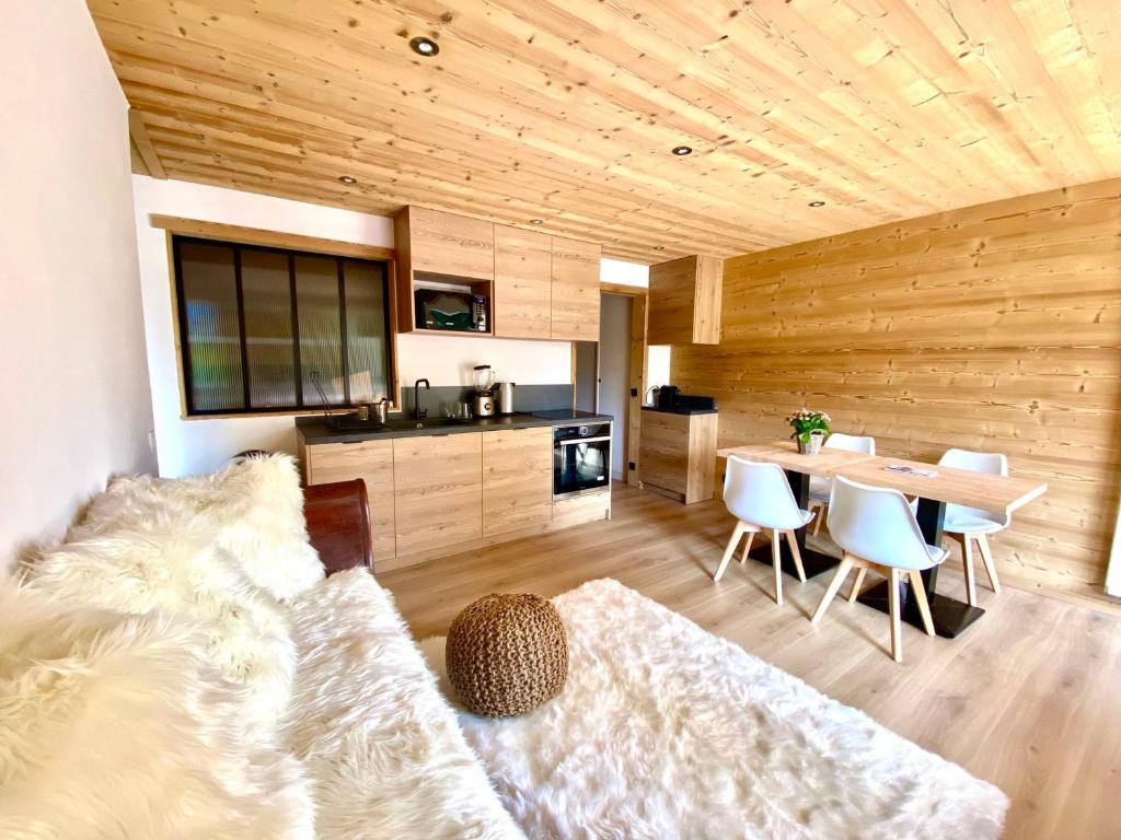 un salon avec un canapé et une table avec des chaises dans l'établissement Appartement cosy avec 2 chambres, balcon et piscine - Proche du centre de Megève - FR-1-453-282, à Megève