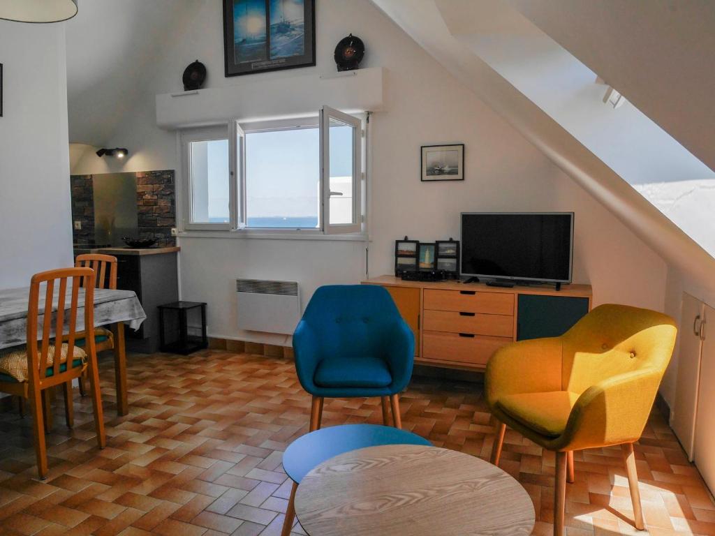 ein Wohnzimmer mit einigen Stühlen und einem TV in der Unterkunft Appartement rénové avec vue mer au Palais, proche commerces - FR-1-418-175 in Le Palais