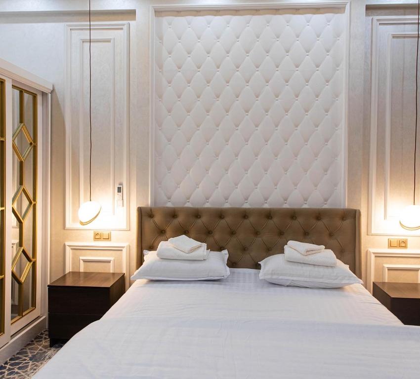 una camera con un grande letto con testiera imbottita di Ardani hotel,Samarqand a Khodzha-Akhrar