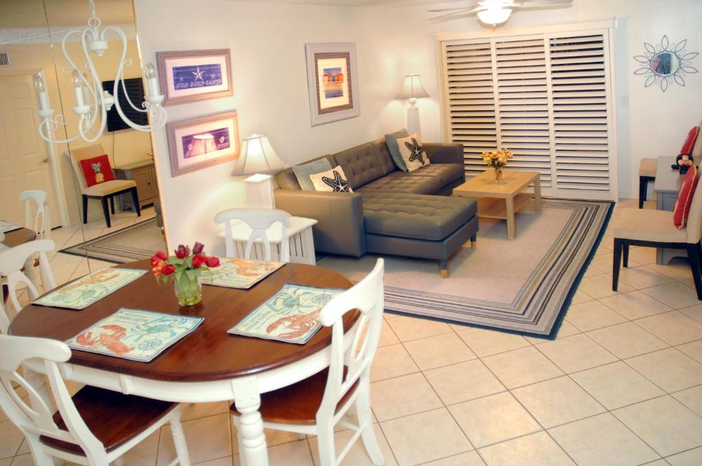 a living room with a table and a couch at Ocean Life Beach Condo - Only Steps to the Beach in Saint Augustine Beach