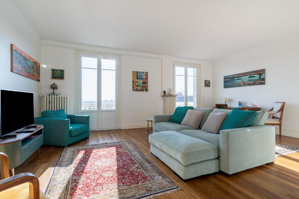 un salon avec un canapé et une télévision dans l'établissement LA SUITE MARCELLIN - Magnifique T3 avec garage et balcon Lyon 7, à Lyon