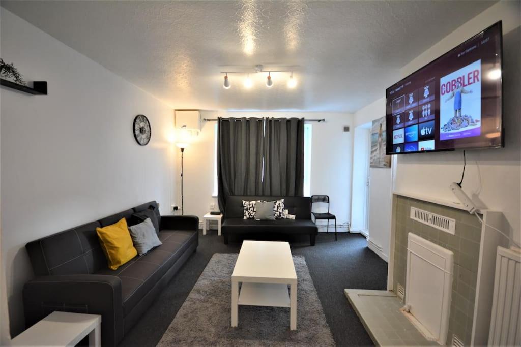 a living room with a couch and a tv at London zone2 Classic 3 bedroom in London