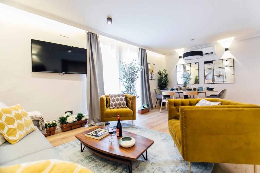 uma sala de estar com mobiliário amarelo e uma mesa em Modern and luxury- 2Bd 2Bth- Socorro em Sevilha