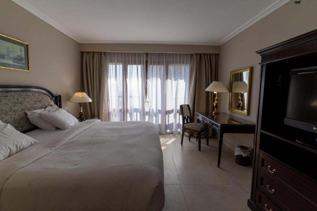 a bedroom with a bed and a desk and a television at Cairo World Trade Center Hotel & Residences in Cairo