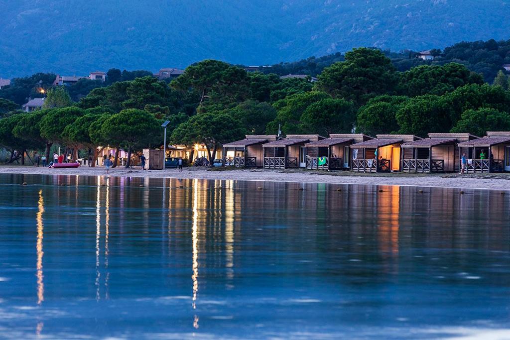 a group of houses on the shore of a body of water at Camping Golfo Di Sogno in Porto-Vecchio