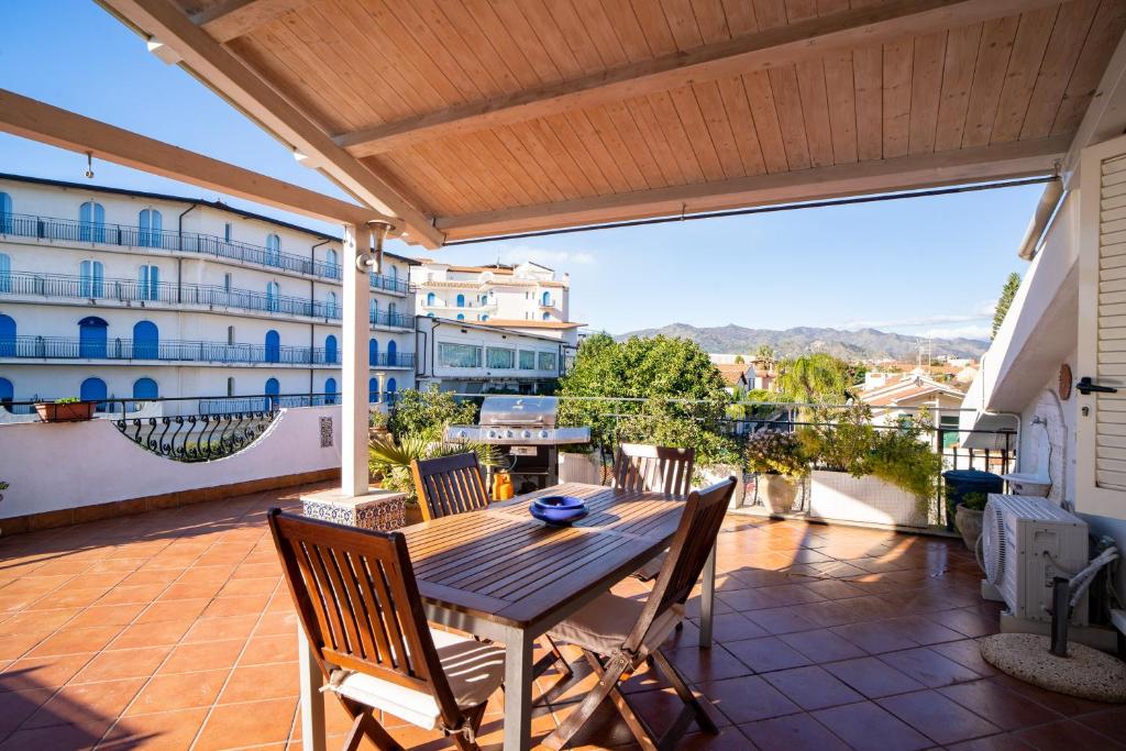 un patio con tavolo e sedie sul balcone. di Casa Vacanza Giugiò a Giardini Naxos