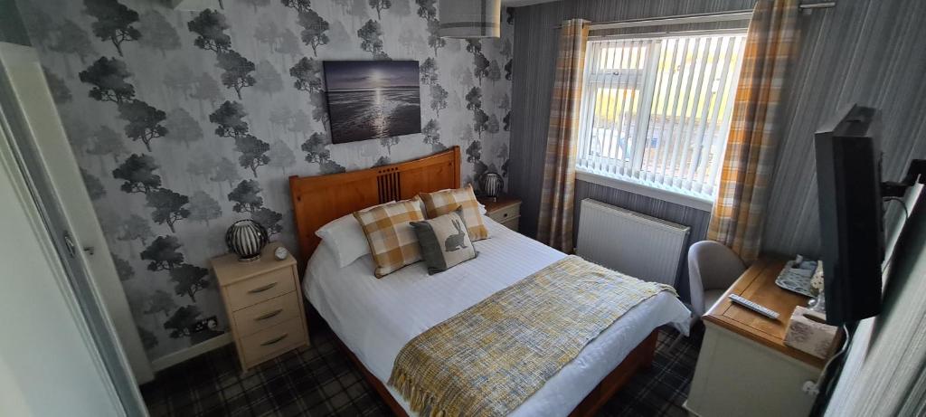 a small bedroom with a bed and a window at Lowefield B&B in Plean