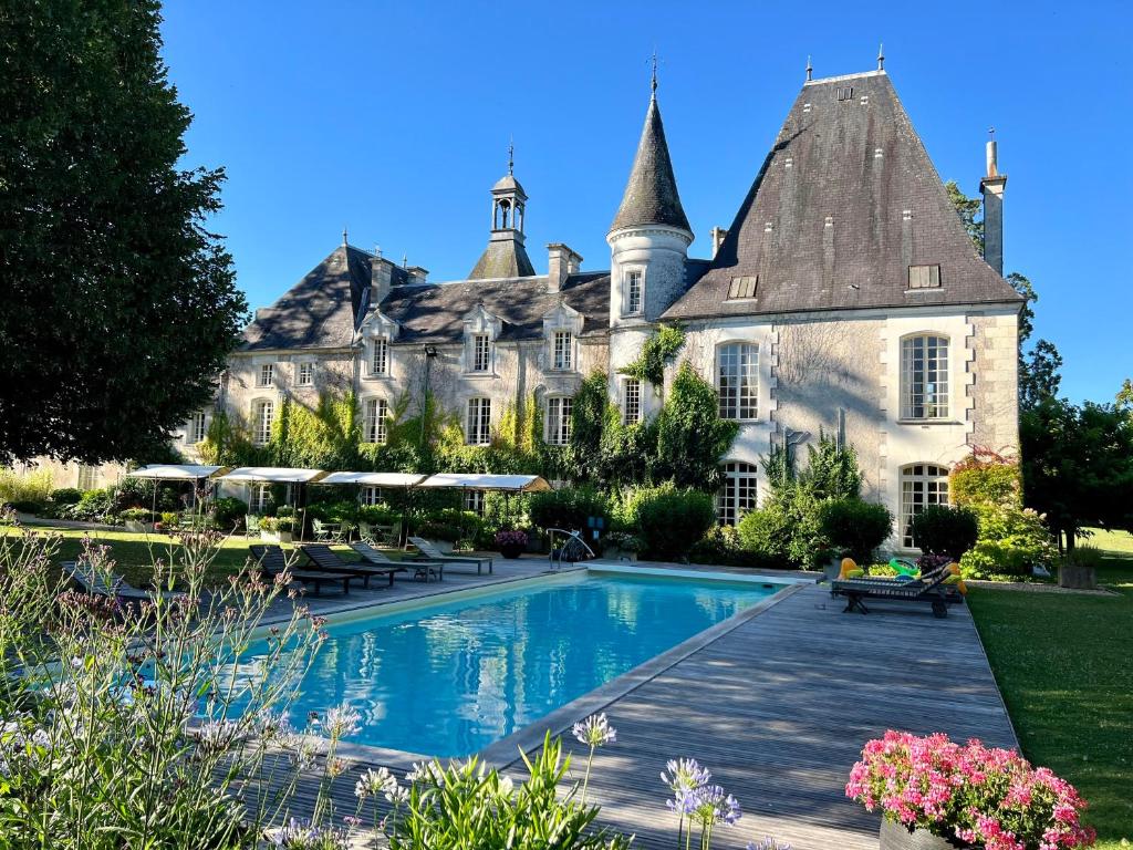 a large house with a swimming pool in front of it at Chateau Le Mas de Montet in Petit-Bersac