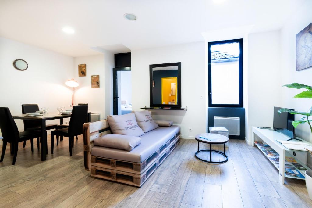 a living room with a couch and a table at LE CÔTÉ COUR in Rodez