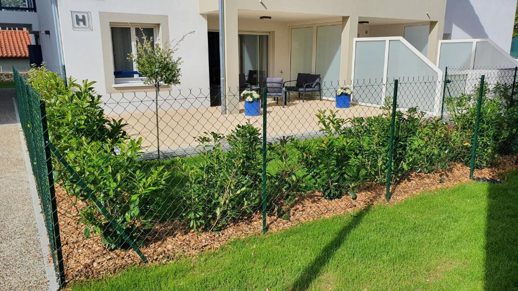 une clôture devant une maison avec des plantes dans l'établissement T2 NEUF ANGLET CENTRE - BIARRITZ, à Anglet