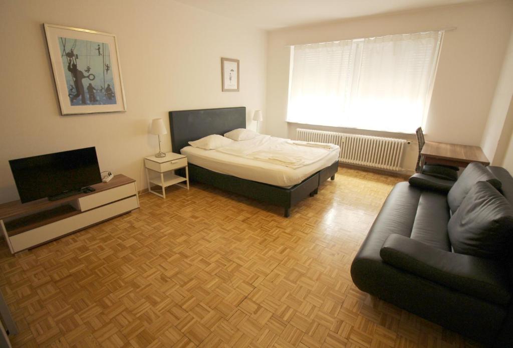 a living room with a bed and a couch at Swiss Star Basel Schweizergasse - Self Check-In in Basel