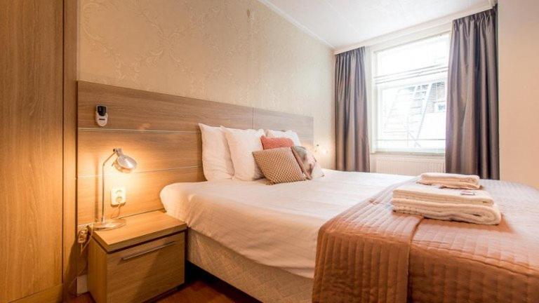um quarto com uma grande cama branca e uma janela em Hotel de Wijnberg em Bolsward