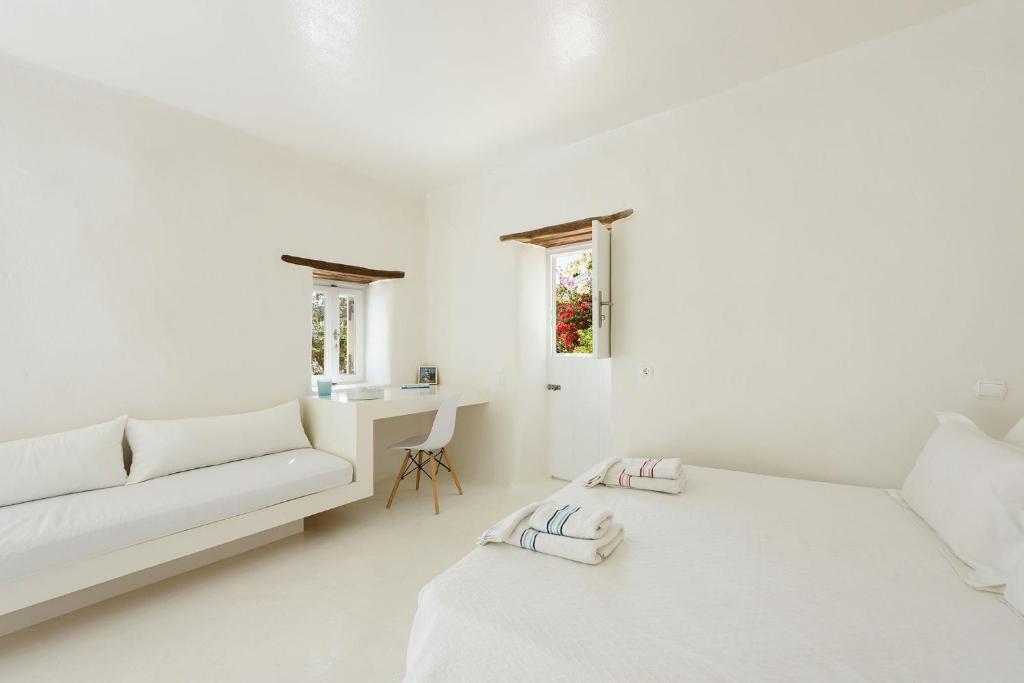 a white living room with a couch and a table at THE OLIVE MILL GUEST HOUSE in Lefkes