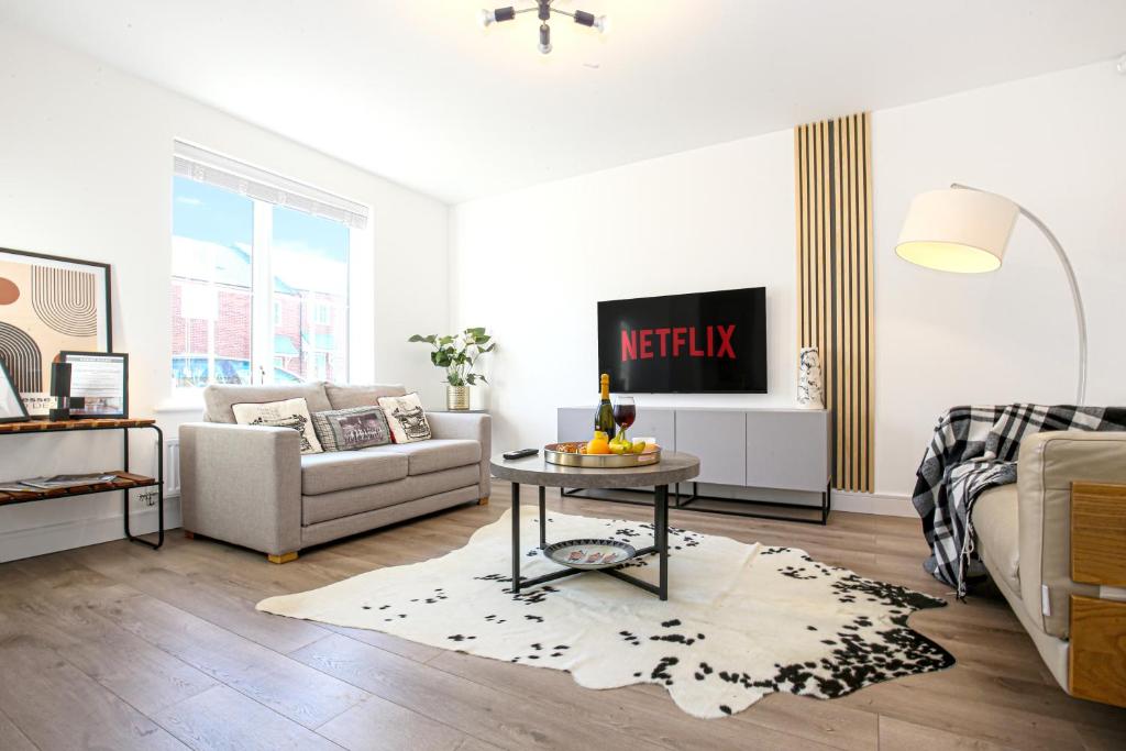 a living room with a couch and a table at Luxury Show Home in Prime Location - Sleeps up to 6 Guests - Free Parking, Fast Wifi, SmartTV with Netflix and Private Garden by Yoko Property in Milton Keynes