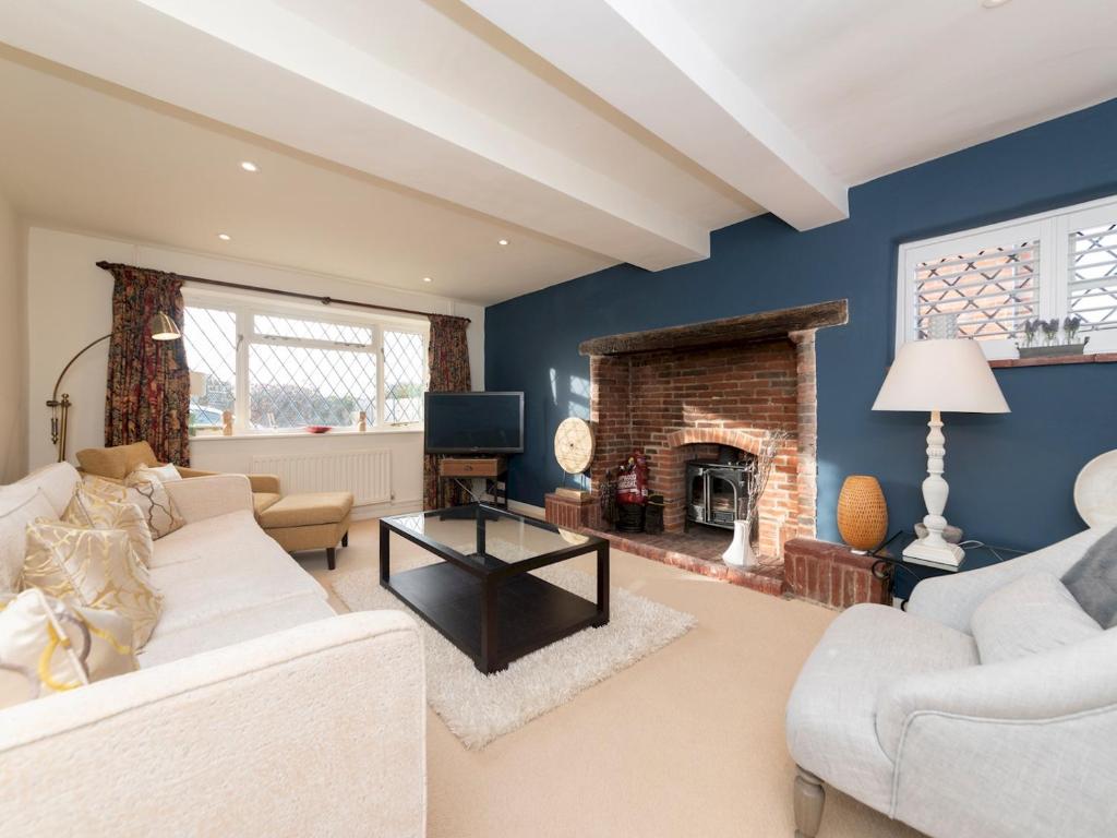 a living room with a couch and a fireplace at Pass the Keys Luxurious Country House with Cinema Games Room in Reading