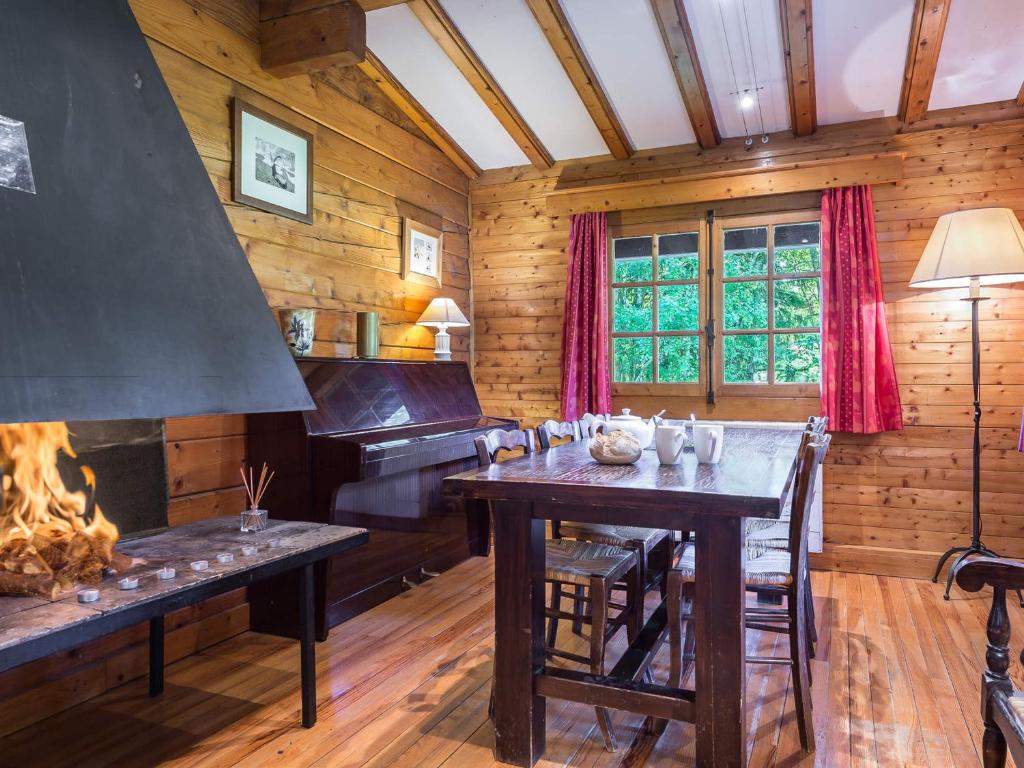 une salle à manger avec une table et un piano dans l'établissement Charmant chalet 2 chambres à Megève Mont d'Arbois, terrasse et jardin, proche des pistes - FR-1-453-255, à Megève