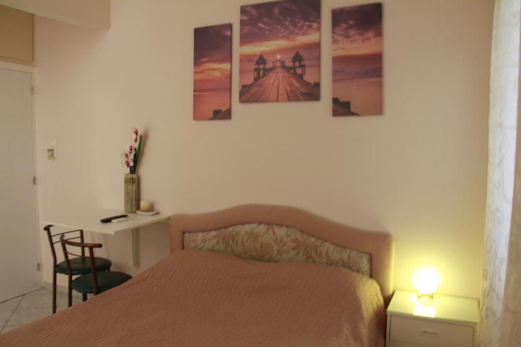 um quarto com uma cama com quatro pinturas na parede em Apartment Eirina em Atenas