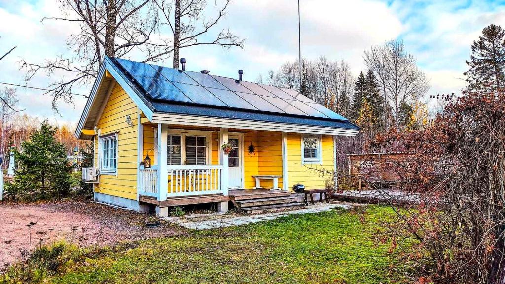 uma pequena casa amarela com um telhado azul em Pikku Torppa Cottage em Kotka
