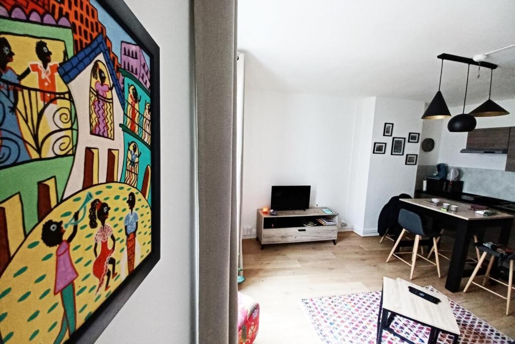 ein Wohnzimmer mit einem Tisch und einem Gemälde an der Wand in der Unterkunft DIEPPE au coeur du cville-Calme avec balcon in Dieppe