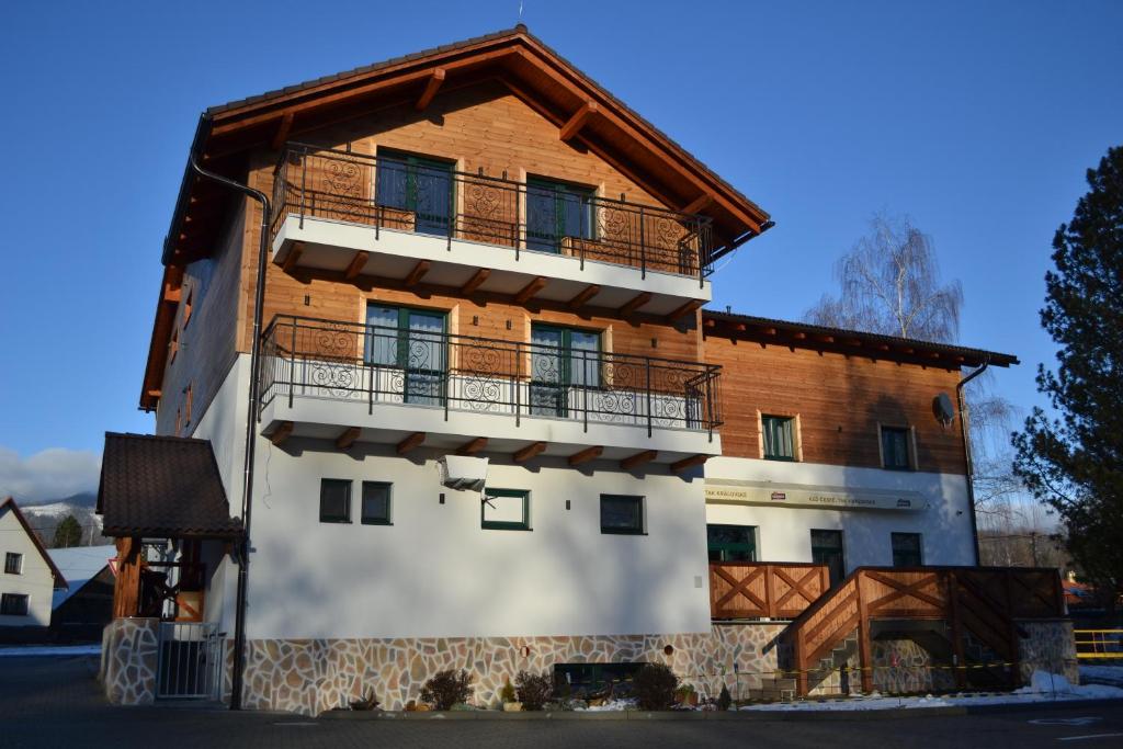 a house with a balcony on the side of it at Tri kopy*** - penzión, reštaurácia a pizza in Smrečany