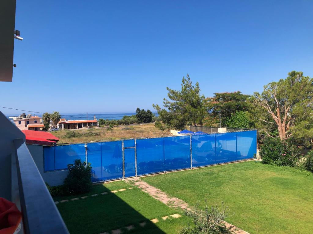 a swimming pool with a blue fence in a yard at Blue Sky in Frangokastello