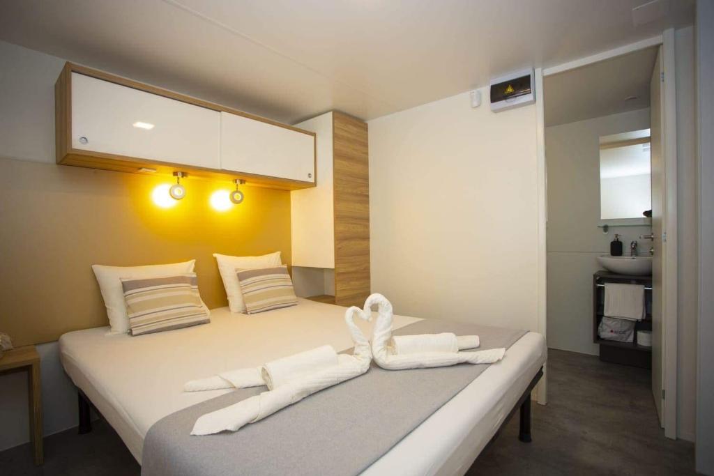 OAZA MIRA 2 Mobile House - Camp Baško Polje في باسكا فودا: غرفة نوم عليها سرير وفوط بيضاء