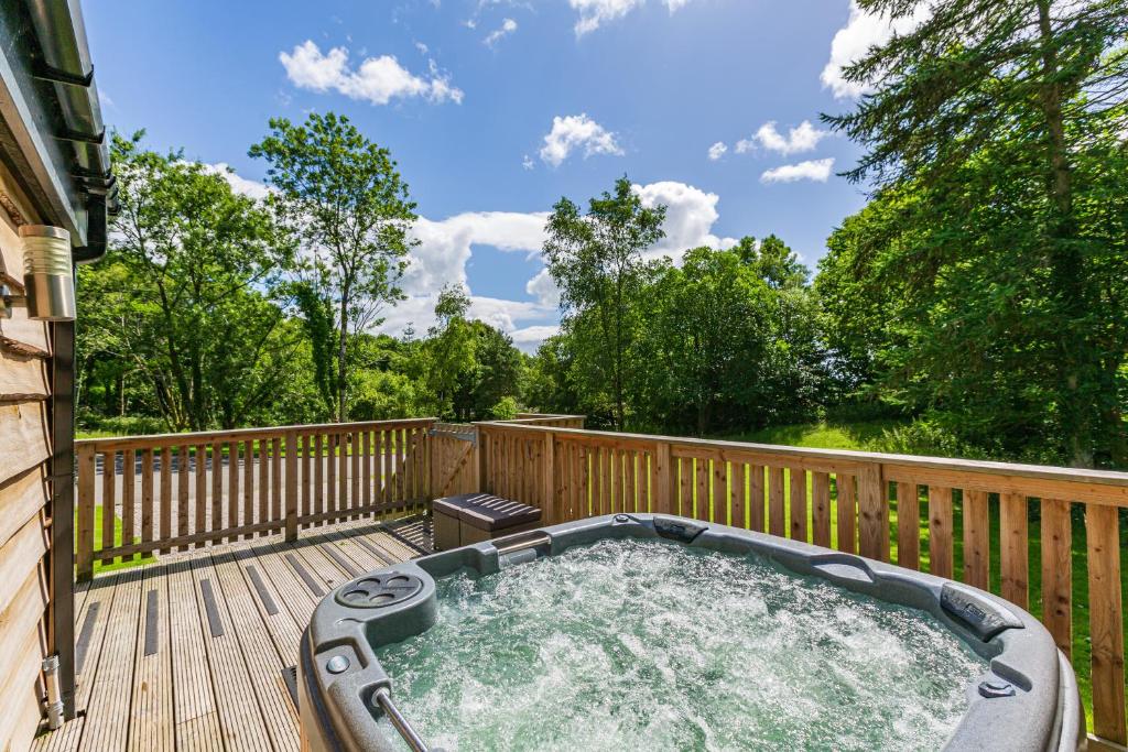 a hot tub on the deck of a house at Squirrel Lodge 40 with Hot Tub in Newton Stewart