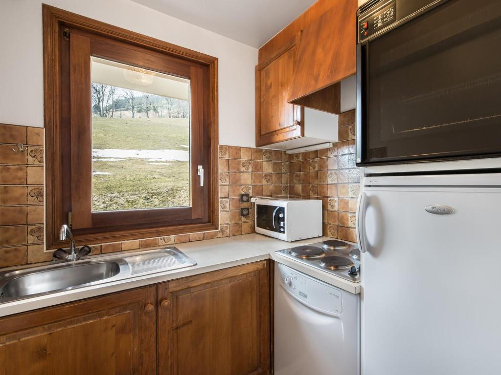 a kitchen with a white refrigerator and a sink at Appartement Megève, 2 pièces, 4 personnes - FR-1-453-51 in Megève