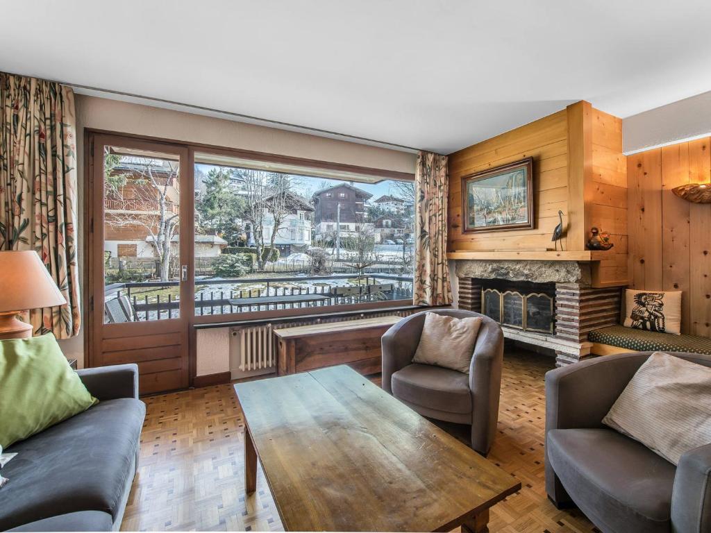 un salon avec une table et une cheminée dans l'établissement Appartement 62m² 4 pers. à Megève - Centre, Balcon Sud/Est, Parking, 2 étoiles - FR-1-453-118, à Megève