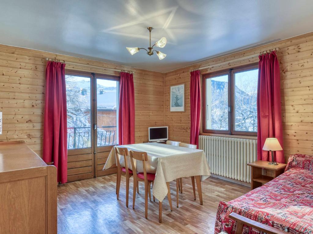 a dining room with a table and red curtains at Appartement Megève, 2 pièces, 3 personnes - FR-1-453-120 in Megève