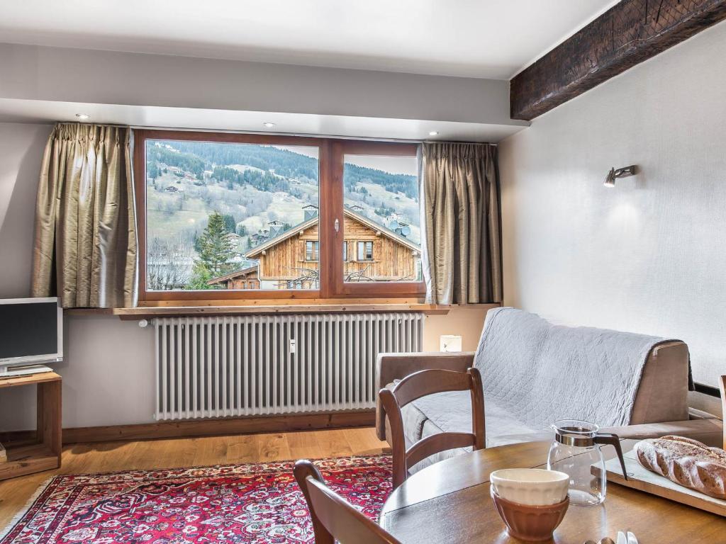 un salon avec une table et une grande fenêtre dans l'établissement Appartement Charmant 2 Pièces, Centre de Megève, 3 Pers., Garage, 3 Étoiles - FR-1-453-106, à Megève