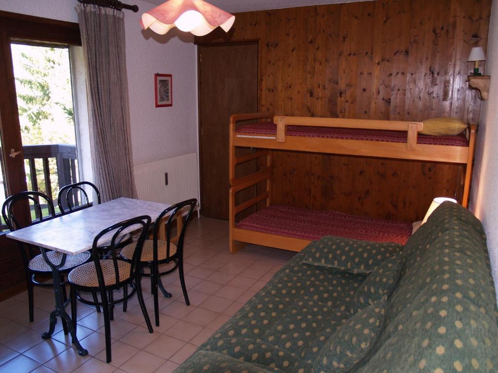 梅傑夫的住宿－Studio Megève, 1 pièce, 3 personnes - FR-1-453-116，客厅配有沙发、桌子和双层床。