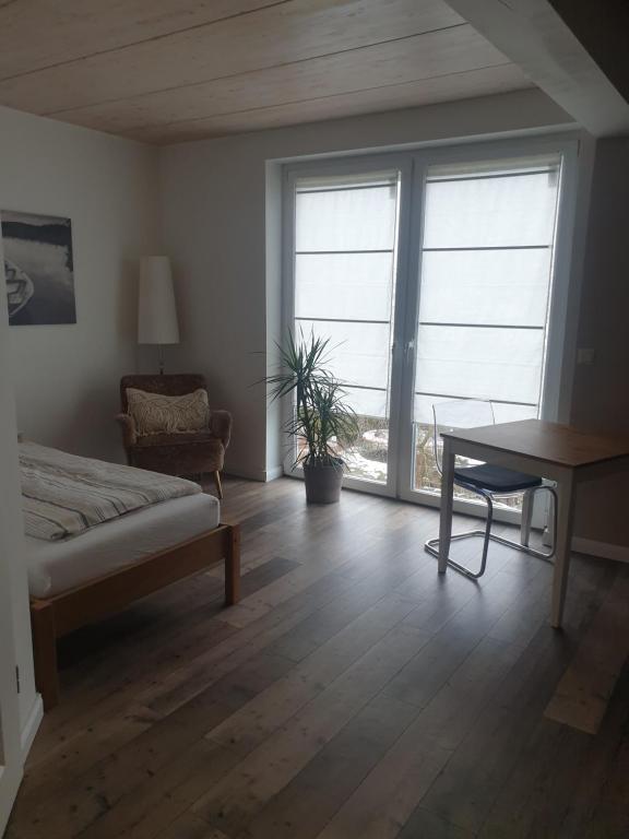 a bedroom with a bed and a desk and a window at Gästehaus Stüpfert Grüber Stein in Grub am Forst