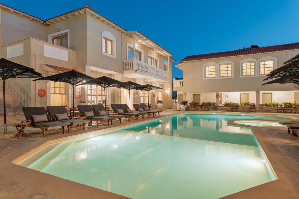 una piscina di fronte a una casa di Ino Village Hotel a Samos