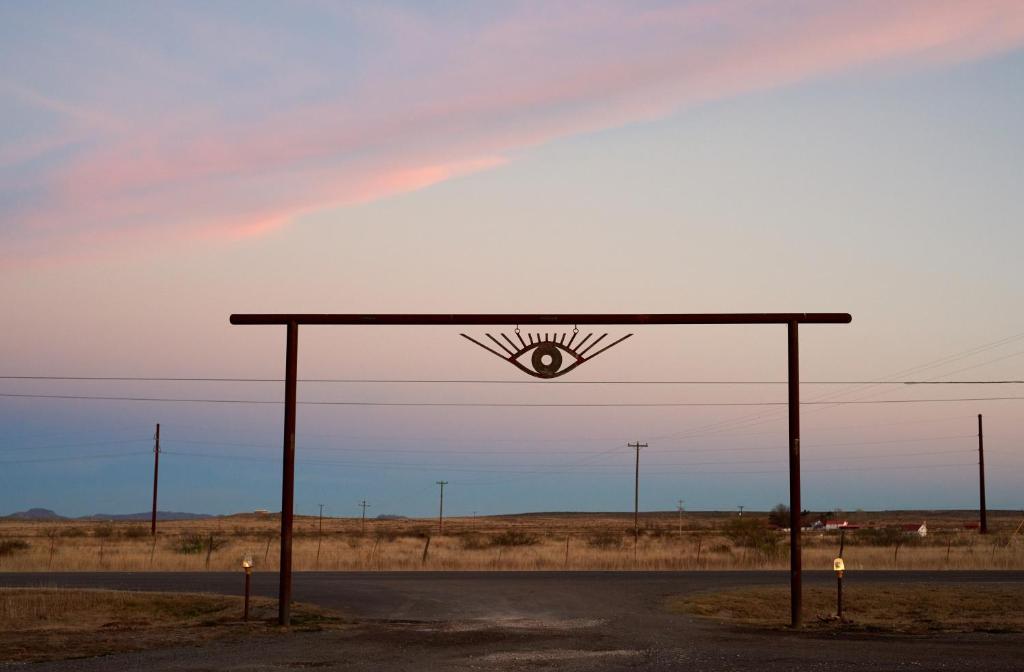 a bus stop with a sign on the side of a road at El Cosmico in Marfa