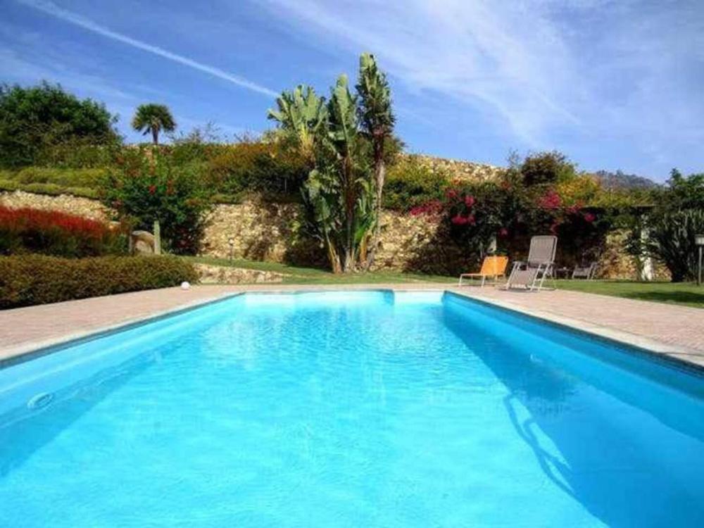 una gran piscina de agua azul en un patio en Villa Azzurra, en Tertenìa
