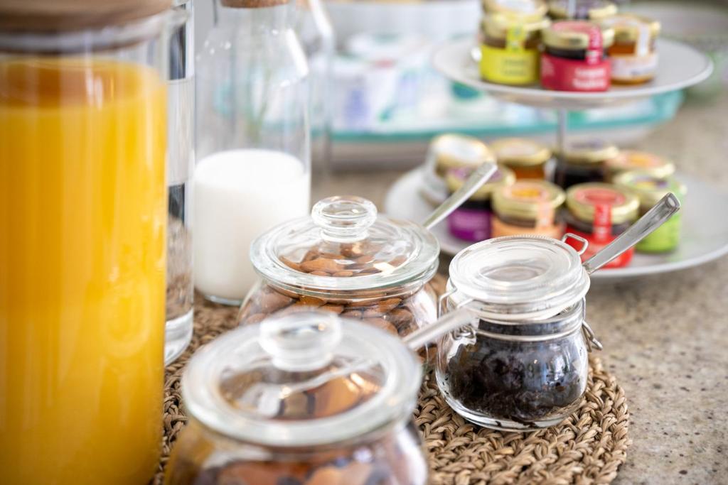 a table topped with jars of food and orange juice at Villa Dalu in Positano