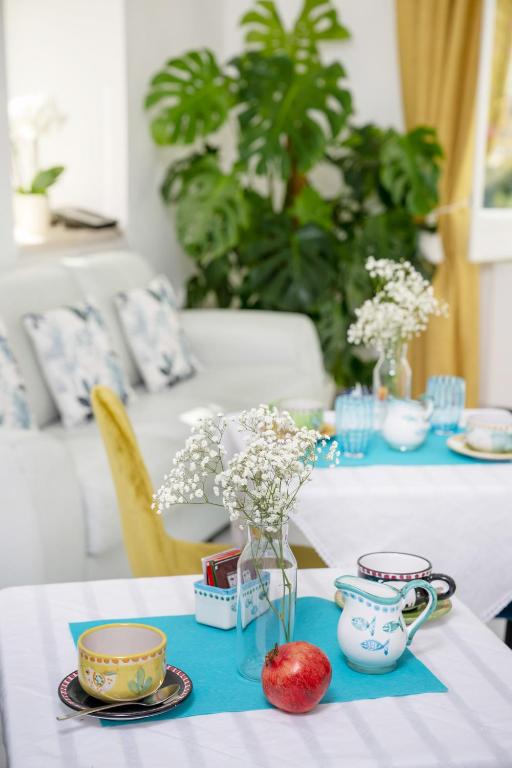 a table with a blue and white table cloth with flowers and cups at Villa Dalu in Positano