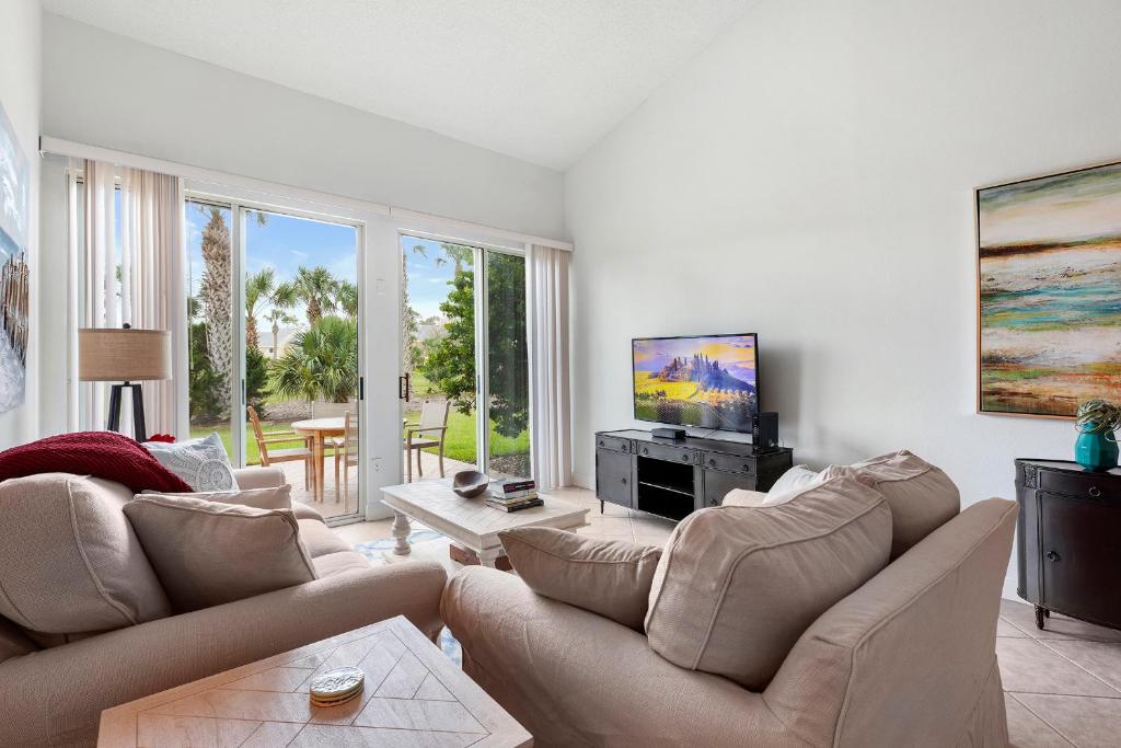 a living room with two couches and a flat screen tv at Fairway Dream - Sawgrass 2 Bedrooms - 2 Bath Villas Sleep 6, Close To Beach in Ponte Vedra Beach