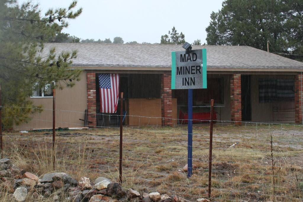 un panneau devant une maison avec une mine de chantier dans l'établissement Mad Miner Inn Washington Camp one night free offer, à Patagonia