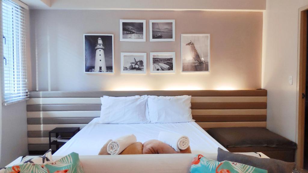 um quarto com uma cama com fotografias na parede em Palm Tree Villas Condominium by Beth em Manila