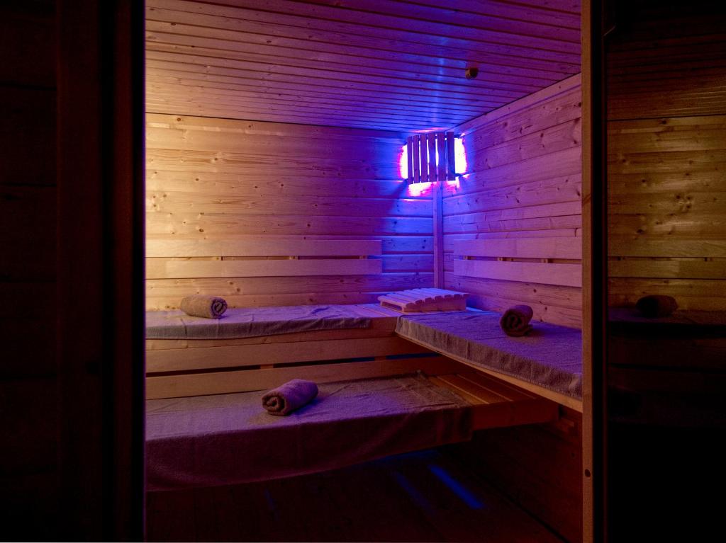 a wooden sauna with purple lights in a room at Gasthof zum Postwirt in Predlitz