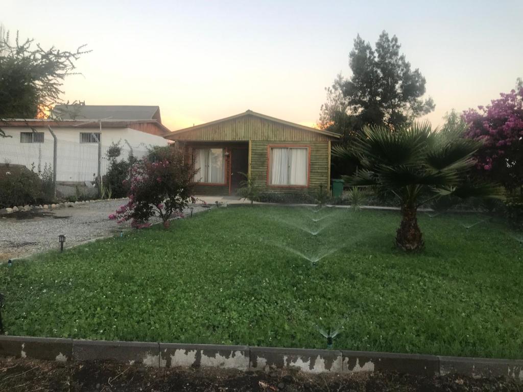 a yard with a house and a palm tree at Cabaña en San Javier de Loncomilla, in Linares