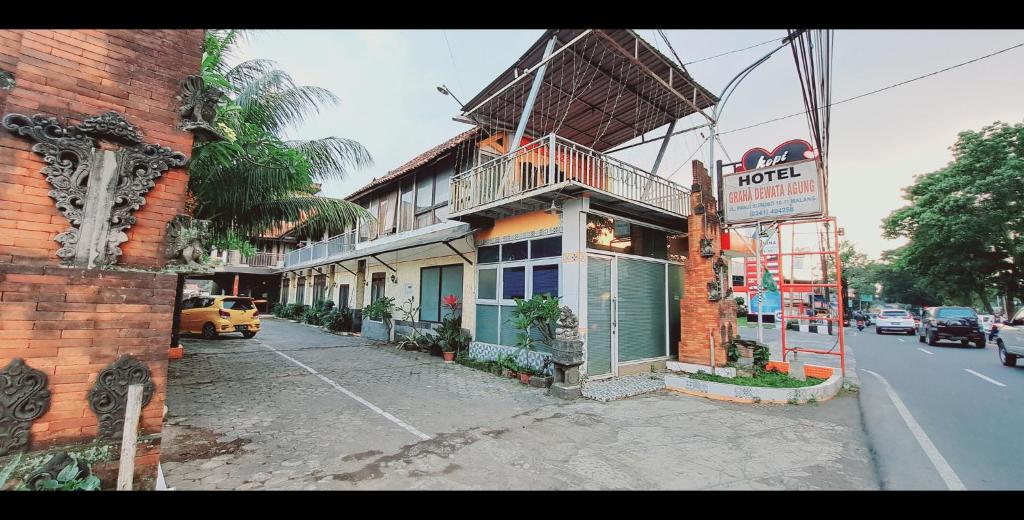 un edificio al lado de una calle con un hotel en Hotel Bali Graha Dewata Agung en Blimbing