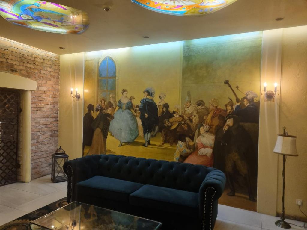 a painting on the wall of a room with a couch at Hotel Wenecki in Częstochowa