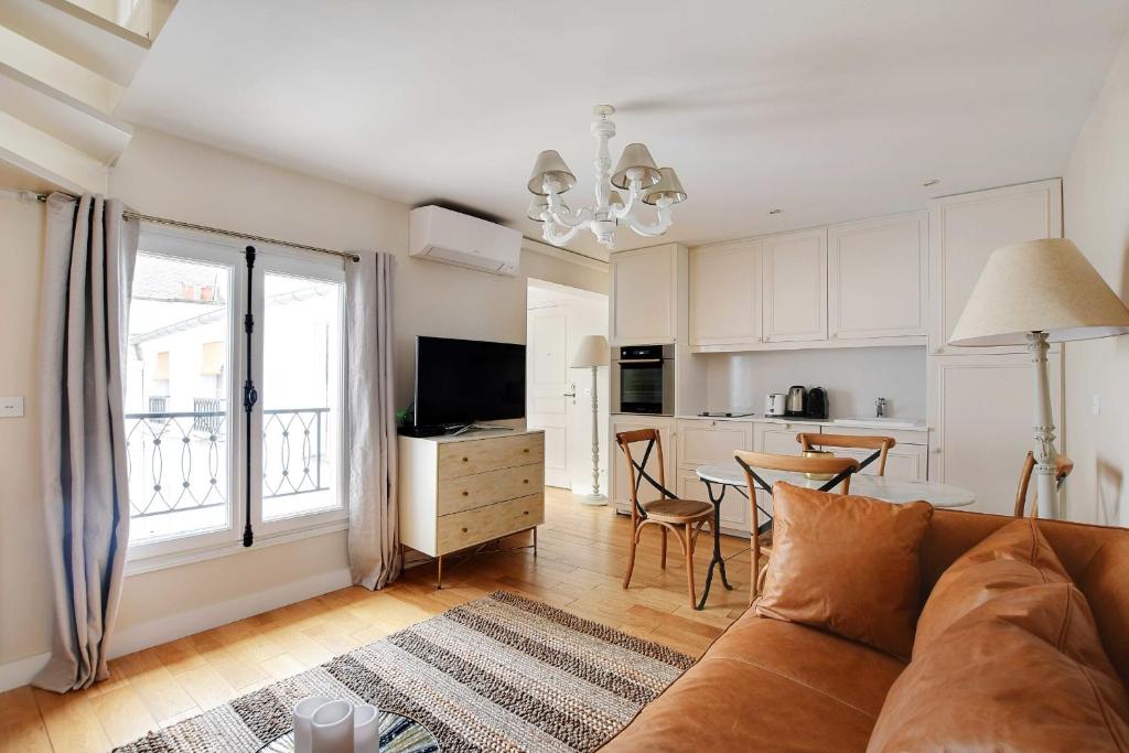 een woonkamer met een bank en een keuken bij Amazing duplex 4P- Louvre Museum Tuileries in Parijs
